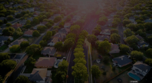 Aerial view of a residential community with single-family homes, tree-lined streets, and green spaces, showcasing HOA-managed properties.