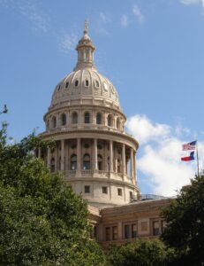 The Texas State Capitol in Austin, TX, a historic landmark surrounded by lush greenery, representing the heart of Texas government and culture.